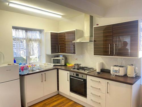 uma cozinha com armários brancos e uma bancada em West Bishop Auckland Professional Let em Bishop Auckland
