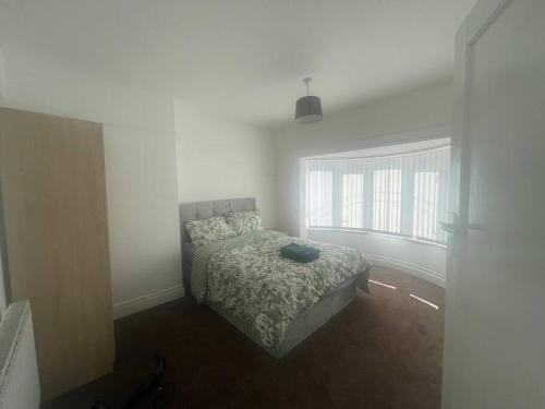a bedroom with a bed and a large window at West Bishop Auckland Professional Let in Bishop Auckland