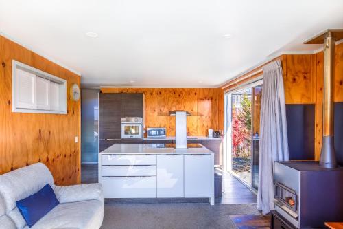 a living room with a couch and a kitchen at Tekapo Blue Cottage in Lake Tekapo