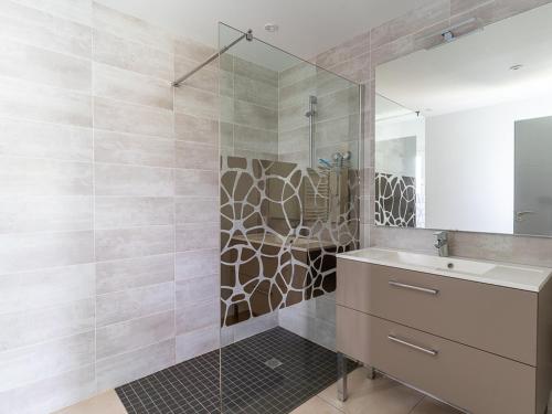 un bagno con doccia, lavandino e specchio di Maison de 40m² à Biscarrosse - Proche lac, pistes cyclables, plage - Accueille 4 pers. - Animaux OK - FR-1-319-484 a Biscarrosse