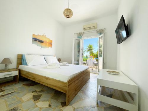 a bedroom with a bed and a tv and a table at Odysseas Apartments in Marathokampos
