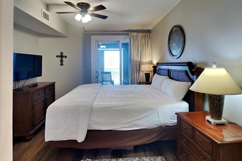 1 dormitorio con 1 cama grande y TV en Grand Panama Beach Resort - The Grand 403 en Panama City Beach