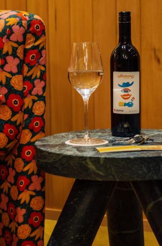 a bottle of wine and a glass on a table at Waymore's Guest House & Casual Club in Nashville