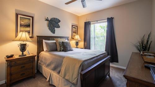 1 dormitorio con 1 cama con 2 lámparas y una ventana en Sunny`s Florida Villa, en Haines City