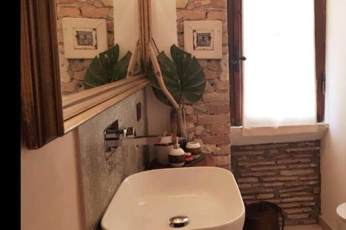 a bathroom with a toilet and a window and a plant at L'Archetto Apartment in Civitavecchia