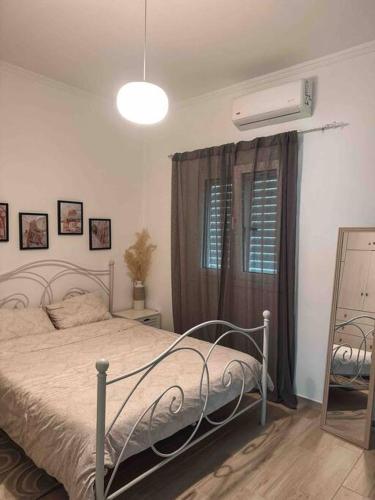 a bedroom with a bed and a fan and a window at Paradise House in Arkoudi