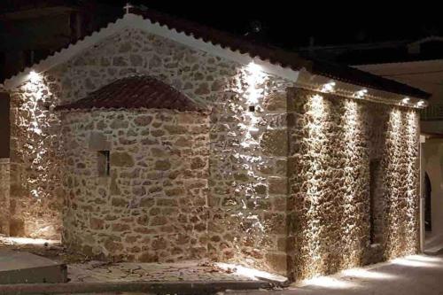 a stone building with lights on it at night at Paradise House in Arkoudi
