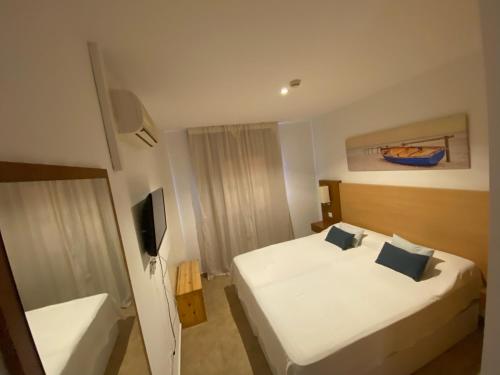 Habitación de hotel con cama y TV en Punta Umbria ideal apartamento Enebrales, en Punta Umbría