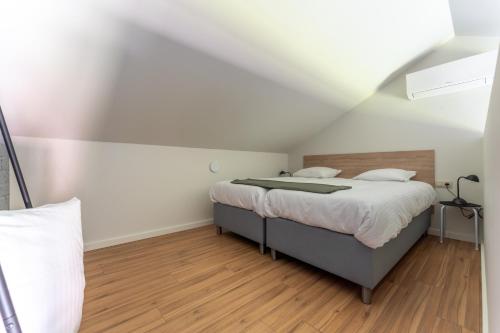 a bedroom with a bed in a attic at De Hoog Velden 13 in Pelt