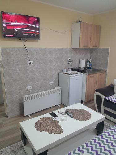 una pequeña cocina con mesa blanca y nevera blanca en TINA1, en Valjevo