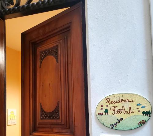 eine Holztür mit einem Schild an der Seite eines Gebäudes in der Unterkunft Residenza FillAnfi in Lucca