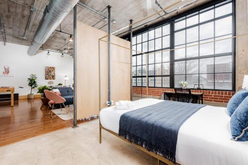 um quarto com uma cama grande e uma sala de estar em CozySuites Stunning 1BR Adler Loft with Parking em Saint Louis