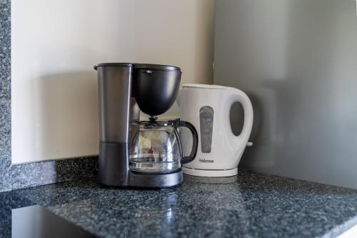 a blender and a coffee maker on a counter at De Hoog Velden 13 in Pelt
