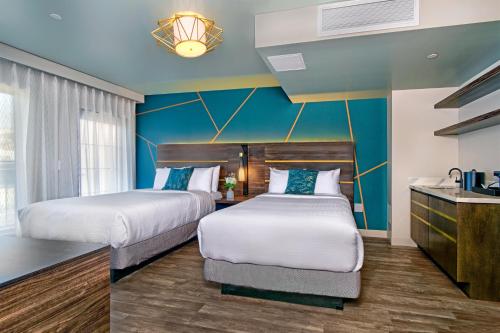 2 camas en una habitación de hotel con paredes azules en Marea Sol Hotel, en Santa Cruz
