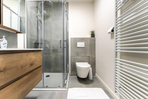 a bathroom with a toilet and a glass shower at De Hoog Velden 13 in Pelt
