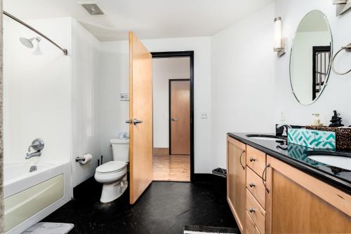 a bathroom with a sink and a toilet and a mirror at CozySuites Gorgeous 2BR penthouse w Skyline view in Saint Louis