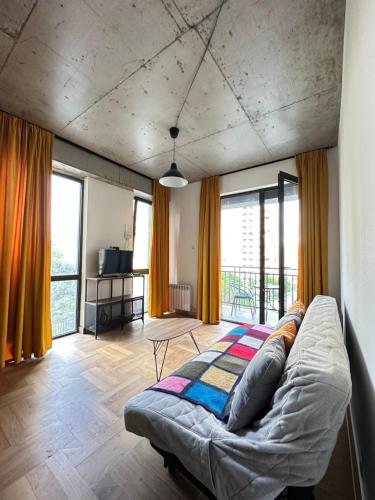 ein Schlafzimmer mit einem Bett in einem Zimmer mit Fenstern in der Unterkunft Gvazi Apartment in Tbilisi City