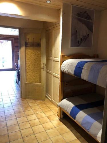 Cette chambre dispose de 2 lits superposés et d'un couloir avec une porte. dans l'établissement Appartement 4 à 6 personnes aux portes du parc de la vanoise, à Champagny-en-Vanoise