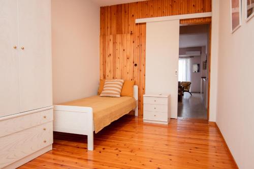 a bedroom with a bed and a wooden floor at ZeusPlace Park View Apartment Paralia Katerini in Paralia Katerinis