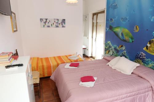 1 dormitorio con 1 cama con un mural de pescado en la pared en Le Gardenie b&b, en Marina di Schiavonea