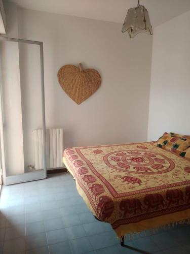 una camera da letto con un letto con un cuore sul muro di La casa di Alba ad Alba Adriatica