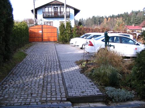 a parking lot with cars parked in front of a house at Penzion Kalina in Tábor