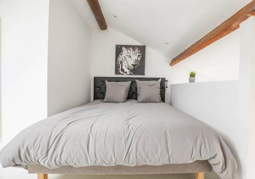 - une chambre blanche avec un lit et une tête de lit en bois dans l'établissement ®L'Urbain - Superbe Mezzanine, à Marseille