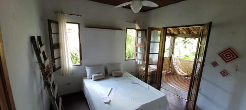 Habitación con cama, espejo y puerta en Goura House Ilhabela, en Ilhabela