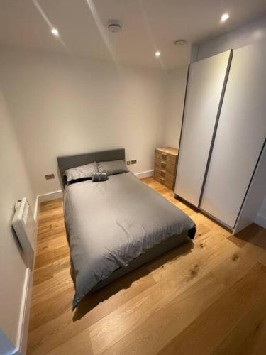 a bedroom with a bed in the middle of a room at Vibrant flat in the city centre in Slough