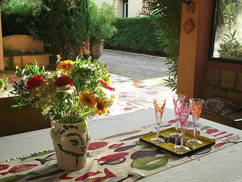 ein Tisch mit zwei Gläsern und einer Vase mit Blumen in der Unterkunft Maison de campagne vue Étang de Thau ! in Frontignan