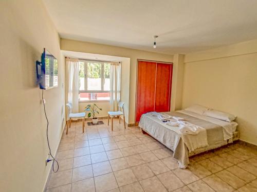 een slaapkamer met een bed, een tafel en een raam bij Monoambiente Elegante y Economico in San Salvador de Jujuy