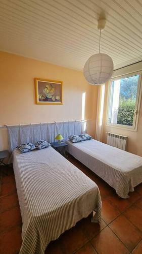 une chambre avec deux lits et une fenêtre dans l'établissement Maison de campagne vue Étang de Thau !, à Frontignan