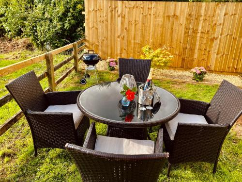 a patio table and chairs in a backyard at Highgate Mountain in Pembrokeshire