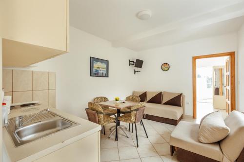 - une cuisine avec un évier et une table dans une chambre dans l'établissement Premium Spot Apartments, à Herceg-Novi