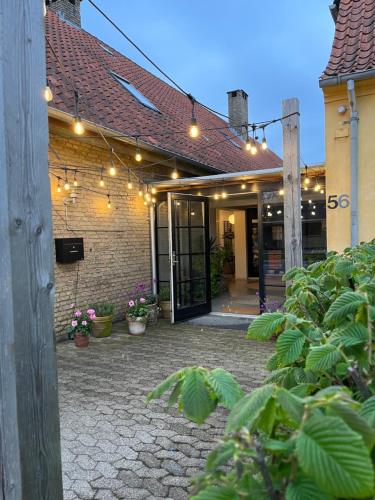 a building with a patio with lights and plants at Room 15 - Hawkraft kulturhotel in Vestervig