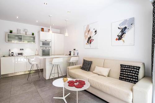 Il comprend un salon blanc avec un canapé et une cuisine. dans l'établissement Stunning 2 bedroom flat, 2 min from the Croisette, à Cannes