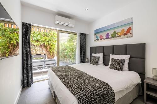 une chambre avec un lit et une grande fenêtre dans l'établissement Stunning 2 bedroom flat, 2 min from the Croisette, à Cannes