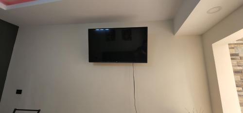 einen Flachbild-TV auf einer weißen Wand in der Unterkunft Altea Hostal in Santa Ana