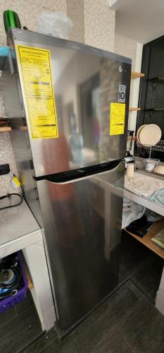 a refrigerator in a kitchen with signs on it at Altea Hostal in Santa Ana