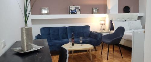 ein Wohnzimmer mit einem blauen Sofa und einem Bett in der Unterkunft Hotel Zona G in Bogotá