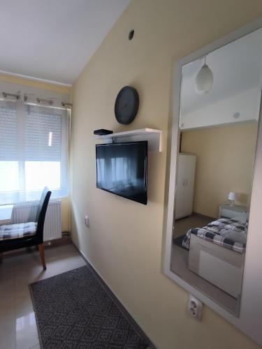 a room with a mirror and a bed and a chair at Studio Apartments Maksimović in Niš