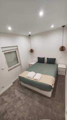 um quarto com uma cama com duas toalhas em Monsanto Central Park em Lisboa