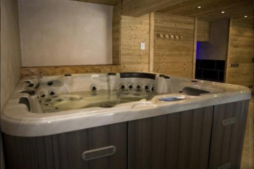 La salle de bains est pourvue d'une baignoire jacuzzi et de murs en bois. dans l'établissement Appartement 4 à 6 personnes aux portes du parc de la vanoise, à Champagny-en-Vanoise