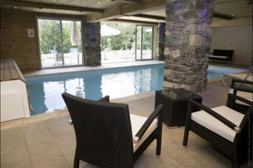 a swimming pool with chairs and a table and some water at Appartement 4 à 6 personnes aux portes du parc de la vanoise in Champagny-en-Vanoise