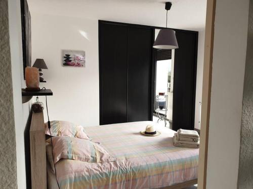 a bedroom with a bed with a hat on it at Superbe appartement avec vue sur lac et montagnes - Station de ski 10 min in Chorges