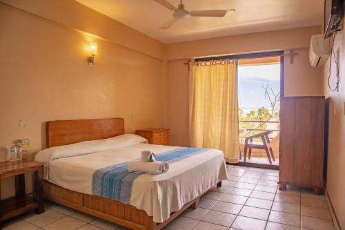 a hotel room with a bed and a balcony at Hotel El Mirador in Puerto Escondido