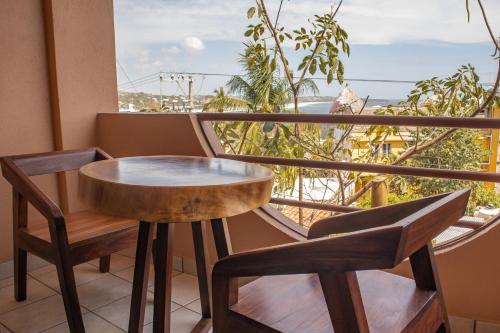 a table and chairs on a balcony with a view of the ocean at Hotel El Mirador in Puerto Escondido