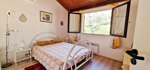 sypialnia z łóżkiem i oknem w obiekcie Appartement du Parc w mieście Patrimonio