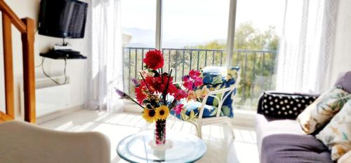 salon z wazą z kwiatami na stole w obiekcie Appartement du Parc w mieście Patrimonio