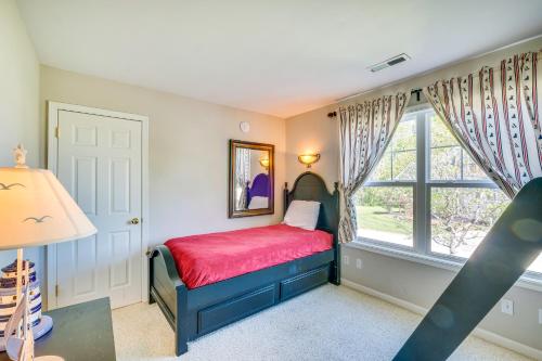 a small bedroom with a red bed and a window at Taylorsville Lake Cottage Rental with Hot Tub! in Taylorsville